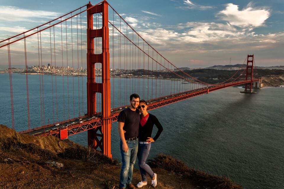 a couple in fron of the Golden Gate bridge